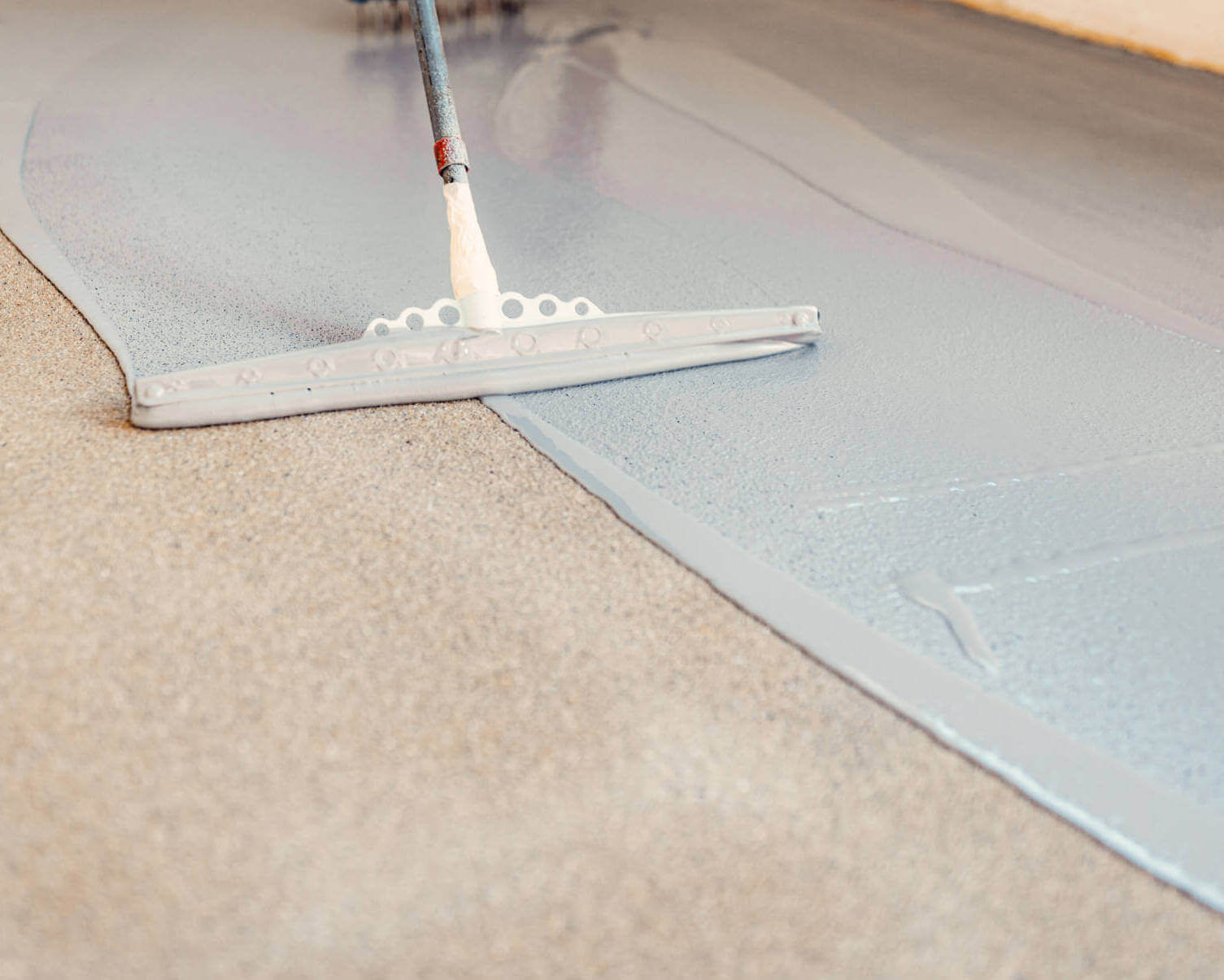 Construction Worker Apply Grey Epoxy Resin In An Industrial Hall